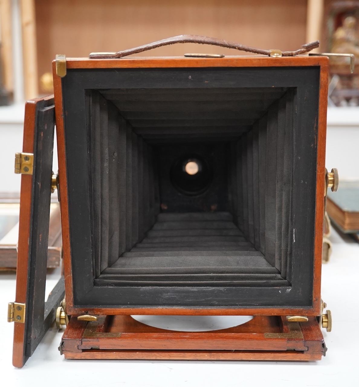 A late 19th/early 20th century brass and mahogany half plate bellows camera with a lens and a shutter action by Thornton Pickard. Condition - glass missing